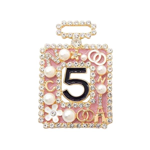 PERFUME-BOTTLE-SHAPED BROOCH  A RHINESTONE FRAME, THE  NUMBER "5" IN THE CENTER, AND SMALL EMBELLISHMENTS  INCLUDING PEARLS, FLOWERS, AND THE EIFFEL TOWER  24