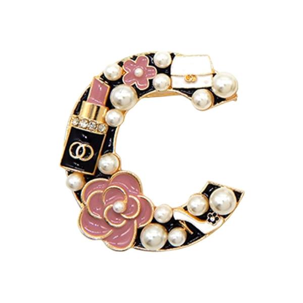 C-SHAPED BROOCH FEATURING FLOWERS, WHITE PEARLS, A LIPSTICK CHARM, AND A PURSE