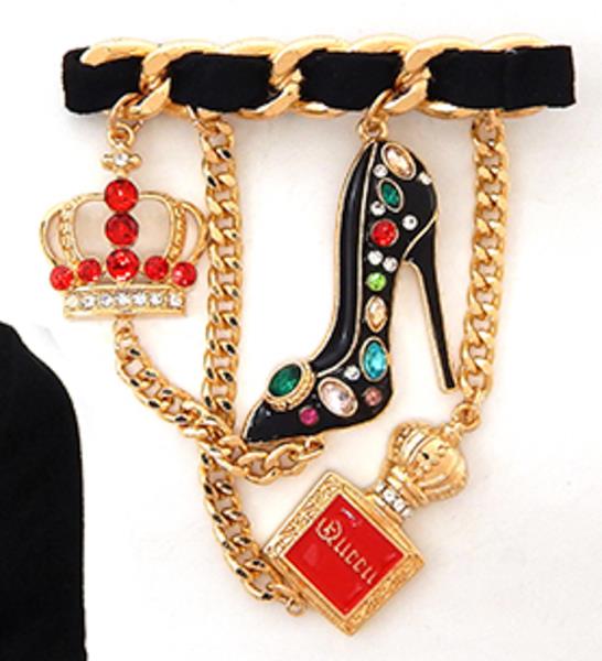 BAR BROOCH FEATURING DANGLING CHARMS OF A HIGH-HEEL SHOE, A CROWN